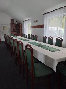 a conference room with a long table and chairs at Cabanele Areama Neagra in Izvoru Mureşului