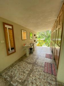 a bathroom with two sinks and a mirror and a hallway at Pura Vida Mini Hostel Santa Teresa in Santa Teresa Beach