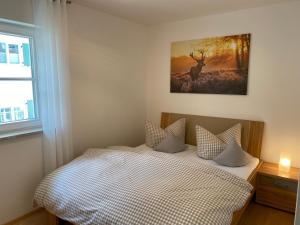 a bedroom with a bed with a picture of a deer at Edelweiss - fewo-badhindelang in Bad Hindelang