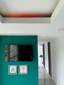Habitación con TV de pantalla plana en la pared en Moderno apartamento con vista a las montañas, en Manizales