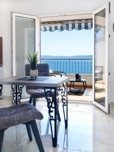 a dining room with a table and a view of the ocean at Villa Sirenis in Trogir
