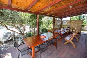 an outdoor patio with wooden tables and chairs at Ferienhaus Elena in Karlobag