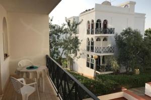 a balcony with a table and a building at Tavira Garden- 2 bedrooms-2pools-2 balconies in Tavira
