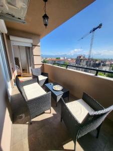 a balcony with chairs and tables and a view of a city at Luxury Central Apartment in Strumica