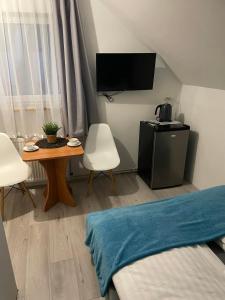 una pequeña sala de estar con una mesa y una cama en Pokoje I Apartamenty Polna 19, en Niechorze