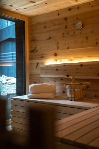 a sauna with a wooden wall and a basket of towels at Amus Chalets Dolomites - Luxury Chalets South Tyrol in Anterselva di Mezzo