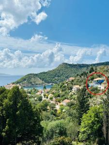 uma casa no topo de uma colina com árvores em Assos BLUE house em Asos