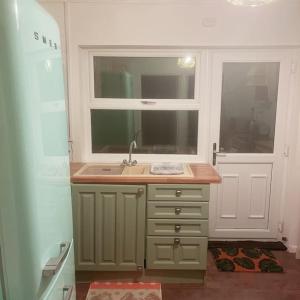 a small kitchen with a sink and a window at Floss Cottage in Matson