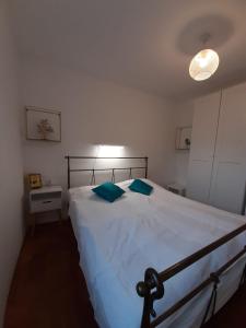 a bedroom with a large white bed with blue pillows at Cosy, sea view apartment Porat in Porat