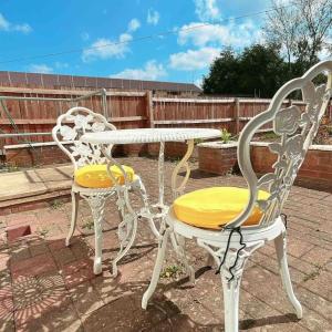 due sedie bianche e un tavolo con un sedile giallo di Floss Cottage a Matson