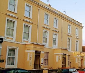 um edifício amarelo com carros estacionados em frente em The Kynance House on Plymouth Hoe ,26 Ensuite Rooms em Plymouth