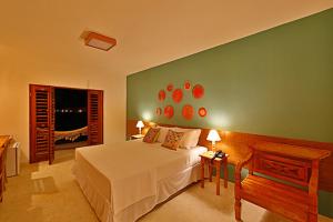 a bedroom with a white bed and a green wall at Angá Beach Hotel in São Miguel dos Milagres