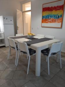 a white table with chairs and a bowl of fruit on it at Cosy, sea view apartment Porat in Porat