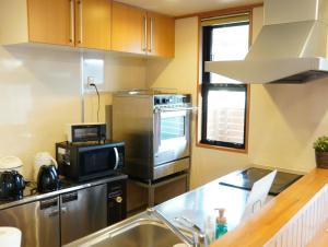 a kitchen with a sink and a microwave at HataraColiving - Vacation STAY 24095v in Chichibu