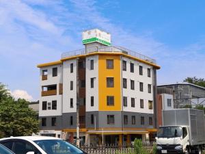 een geel en wit gebouw met auto's voor het gebouw bij HataraColiving - Vacation STAY 24095v in Chichibu