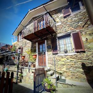 uma casa de pedra com uma varanda e uma cerca de madeira em CA' VERDEMARE em Varazze