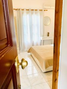 a bedroom with a bed and a window at Skopelos Inn in Stafylos