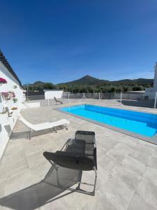 a chair sitting on a patio next to a swimming pool at El Gallinero in Almoharín