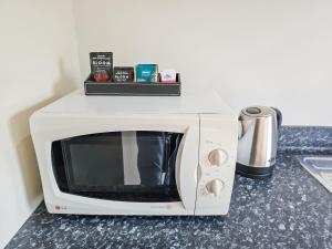 a white microwave oven sitting on top of a counter at Captain Cook Motor Lodge in Gisborne