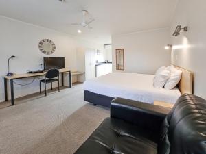 um quarto de hotel com uma cama e um sofá em Captain Cook Motor Lodge em Gisborne