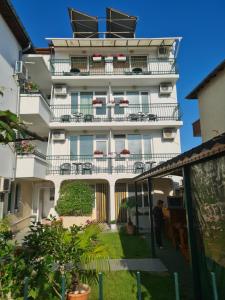 a tall white building with balconies and plants at Къща за гости СТЕЛА in Primorsko