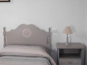 een slaapkamer met een bed en een tafel met een lamp bij Gli Ulivi in Alghero