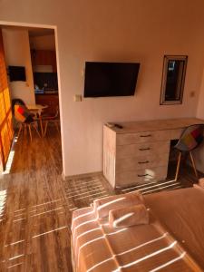 a room with a bed and a television on a wall at Къща за гости СТЕЛА in Primorsko +23 photos