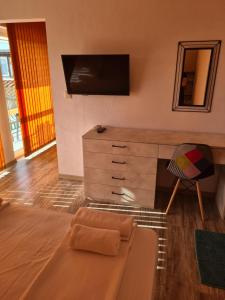 uma sala de estar com uma cómoda e uma cadeira em Къща за гости СТЕЛА em Primorsko