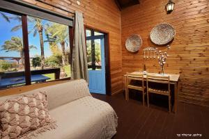 a bedroom with a table and a bed and a table and chairs at בקתה בתמרים in Moshav Ramot +37 photos