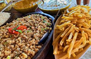 a tray of french fries and a tray of food at Pousada dos Sonhos in Barra