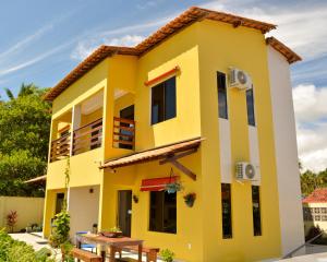 a yellow house with a table in front of it at Pousada dos Sonhos in Barra