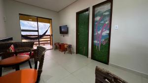 a waiting room with tables and chairs and a window at Pousada dos Sonhos in Barra