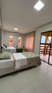 a hotel room with two beds and a balcony at Pousada dos Sonhos in Barra
