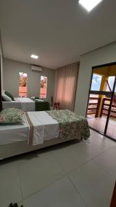 a bedroom with two beds and a large window at Pousada dos Sonhos in Barra