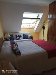 Schlafzimmer mit einem großen Bett und einem Dachfenster in der Unterkunft ATICO AS CORTIÑAS in O Grove