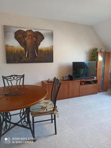 ein Wohnzimmer mit einem Tisch und einem Elefanten an der Wand in der Unterkunft ATICO AS CORTIÑAS in O Grove