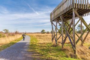 a man walking down a path next to a wooden bridge at Gasthuys de Peel in Ospel