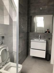 a bathroom with a sink and a toilet and a mirror at Villa Luis in Dziwnów
