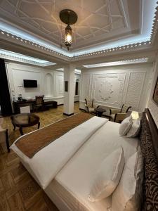 a large bedroom with a large bed and a living room at SHAHRISTAN Plaza in Bukhara