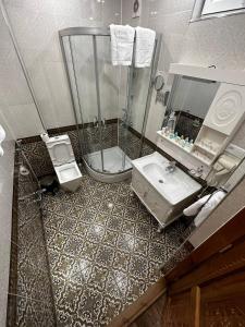 a bathroom with a shower and a toilet and a sink at SHAHRISTAN Plaza in Bukhara