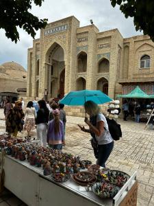 un grupo de personas de pie en frente de un edificio en SHAHRISTAN Plaza, en Bukhara