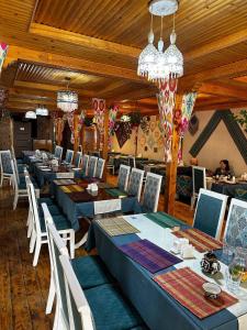 un comedor con mesas azules y sillas blancas en SHAHRISTAN Plaza, en Bukhara