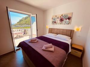 a bedroom with a bed with two towels on it at Guest House Ruža in Sobra