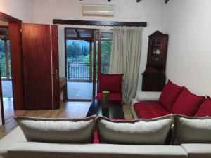 sala de estar con sofá y sillas rojas en Guest House Vjosa en Përmet