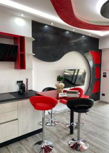 une cuisine avec des tabourets rouges et noirs et un comptoir dans l'établissement La casa di SELLY 2 - A Due Metri Dal Mare-, à Bergeggi