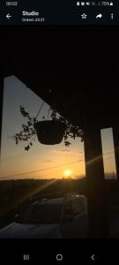 uma fotografia de um pôr-do-sol com um carro à frente em Casa Container Completa! - Beija Flor em Siderópolis