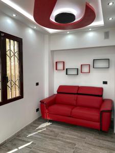 a red couch in a room with a red ceiling at La casa di SELLY 2 - A Due Metri Dal Mare- in Bergeggi