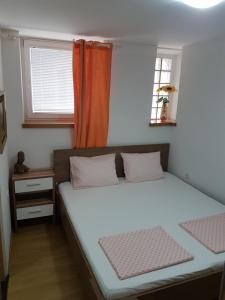 a bedroom with a bed and a window at Karla Babić in Senj