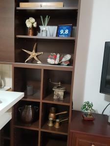 a wooden book shelf with various items on it at Karla Babić in Senj