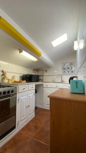 a kitchen with white cabinets and a stove top oven at Apartamento Miradouro in Carrapateira